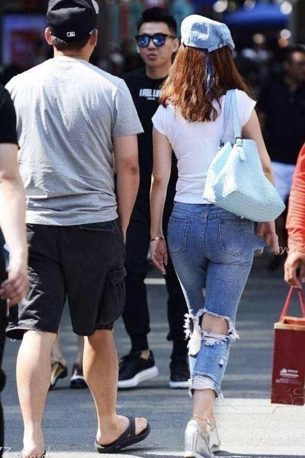 街拍：美女穿破洞牛仔裤，优雅的姿态，充满自信的笑容