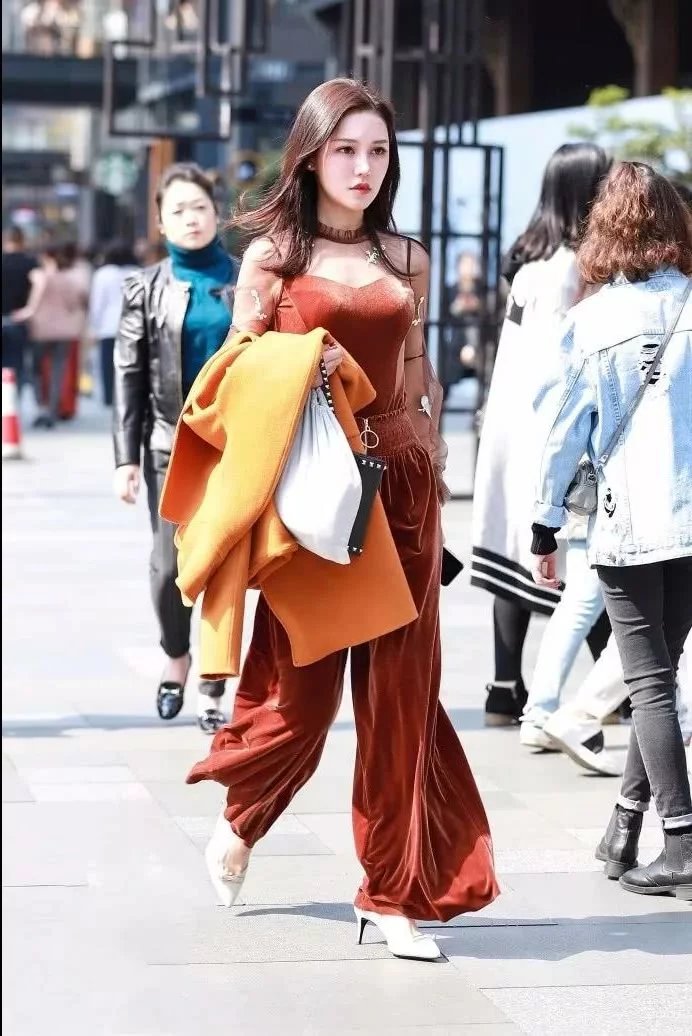 街拍身材饱满的性感美女，上身吊带的样子非常的性感迷人