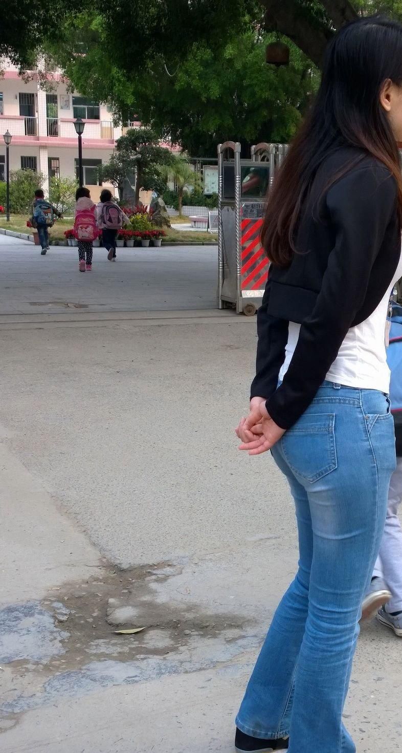 中学门口街拍:美女教师浅蓝色紧身裤搭配黑马甲，显迷人身段