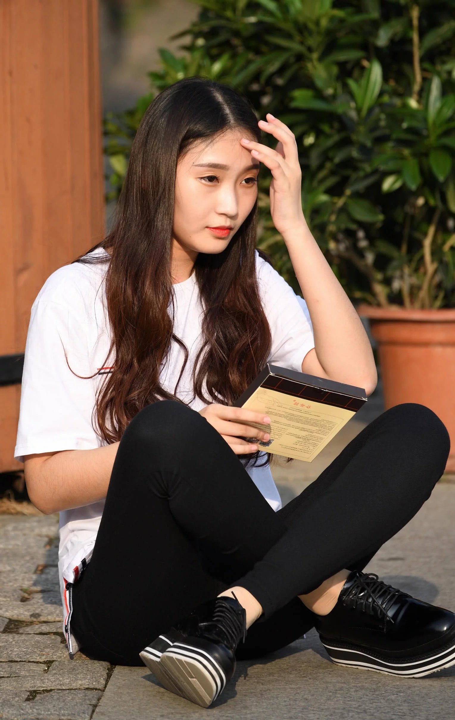 气质小姐姐盘腿坐在路边，紧身裤太紧绷，刚一起身差点儿没摔倒