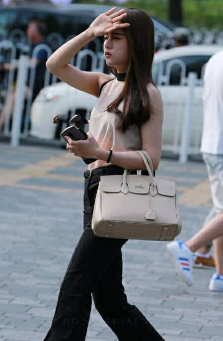 气质小姐姐黑色职业裤青春活力，一手遮阳，俏皮中带着几分可爱