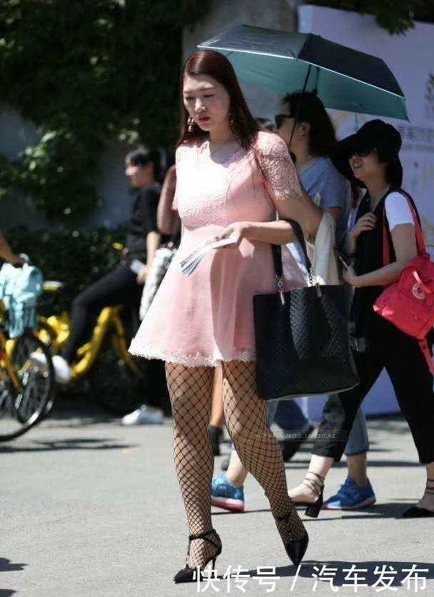 小姐姐粉色连衣裙搭配渔网袜显凹凸有致身材，下身黑色渔网袜成为