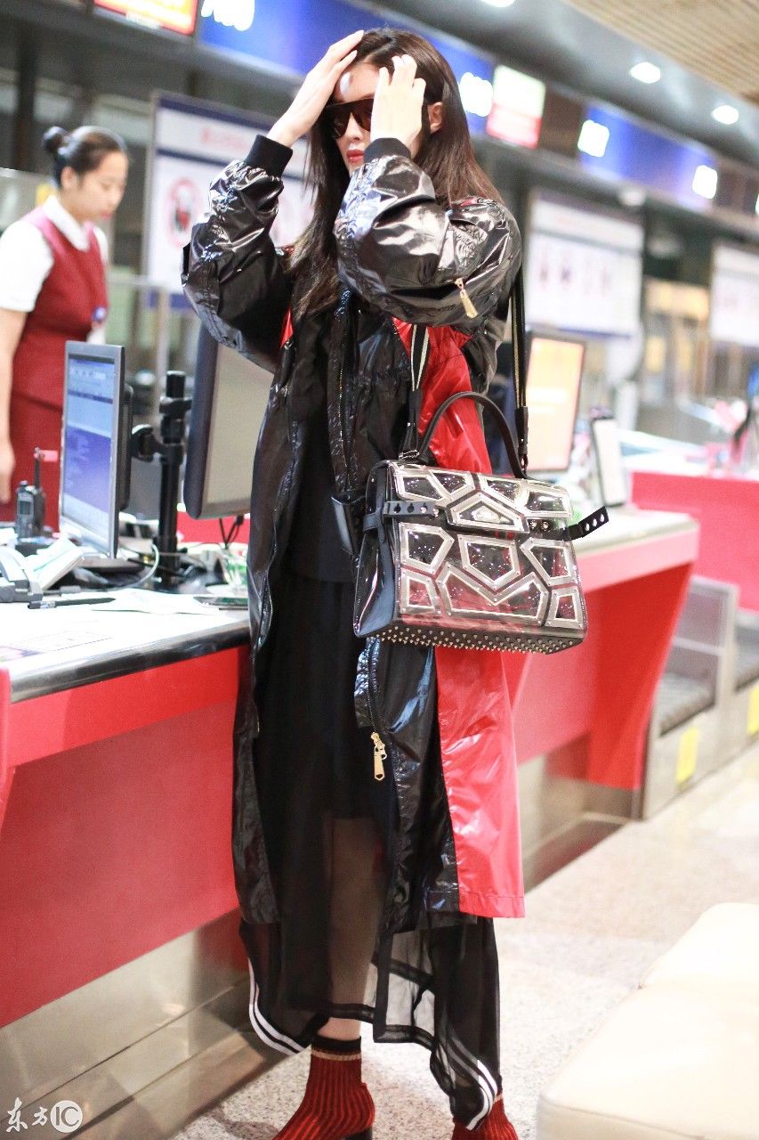 超模何穗现身北京机场，一身雨衣，难掩美腿
