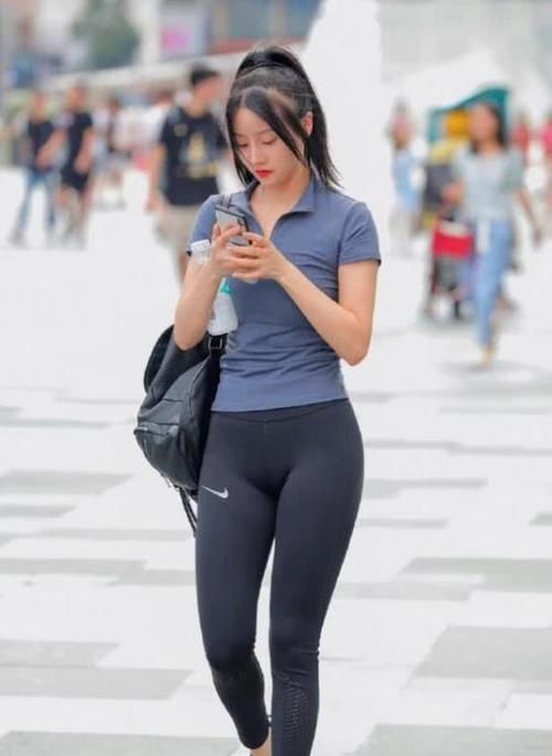  搭配：街拍：气质高雅的美女，一条墨绿色连衣裙外搭黑色开衫，时尚魅力