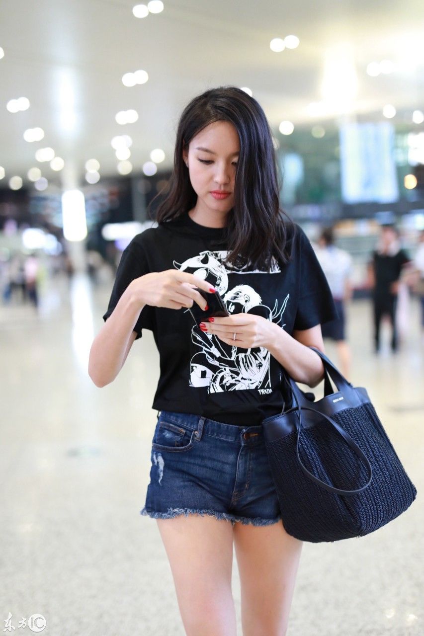张梓琳穿黑色T恤搭配蓝色牛仔短裤现身机场，皮肤白皙秀大长腿