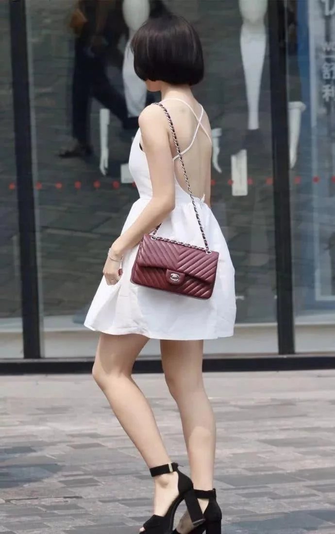 拿手机的小姐姐身穿雪白连衣裙，销魂的背景迷倒一群人