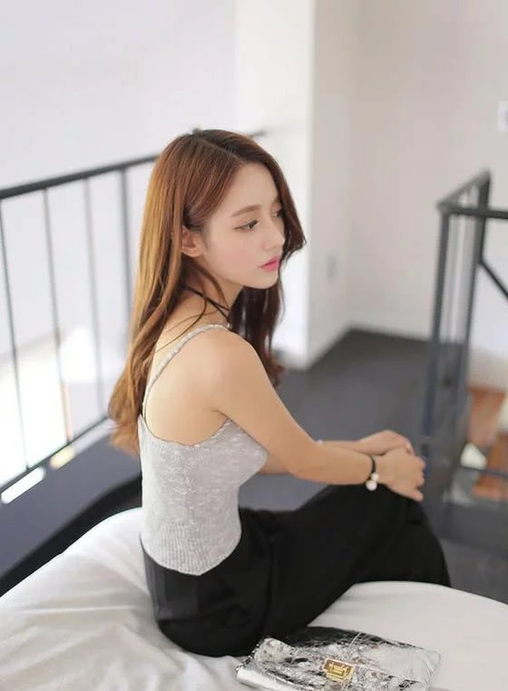 小姐姐身穿吊带上衣，搭配上黑色的修身长裤，尽显迷人的身材曲线