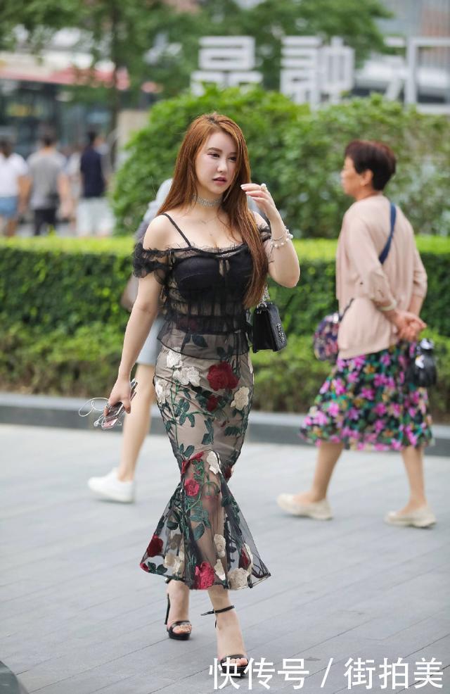 街拍：身穿薄纱吊带衣的小姐姐，胸前还开一个小口，美的很有别致