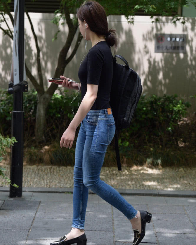 气质小姐姐紧身牛仔裤搭配黑T桖，经典的搭配显出曼妙身材