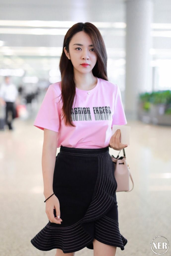 王晓晨穿粉色T恤搭配黑色荷叶边半身裙现身机场，少女感十足