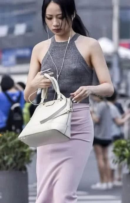街头穿着时尚的美女,高腰包臀裙把身材比例拉伸的不错