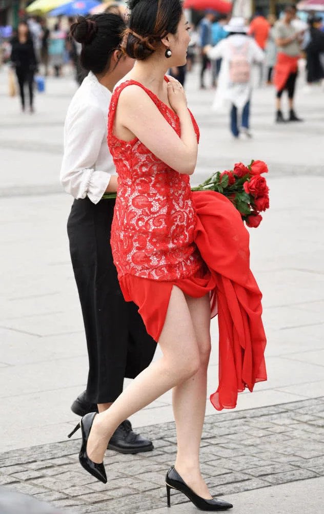 小姐姐穿红色嫁衣撩起裙摆秀出一双白皙美腿，笑容很幸福