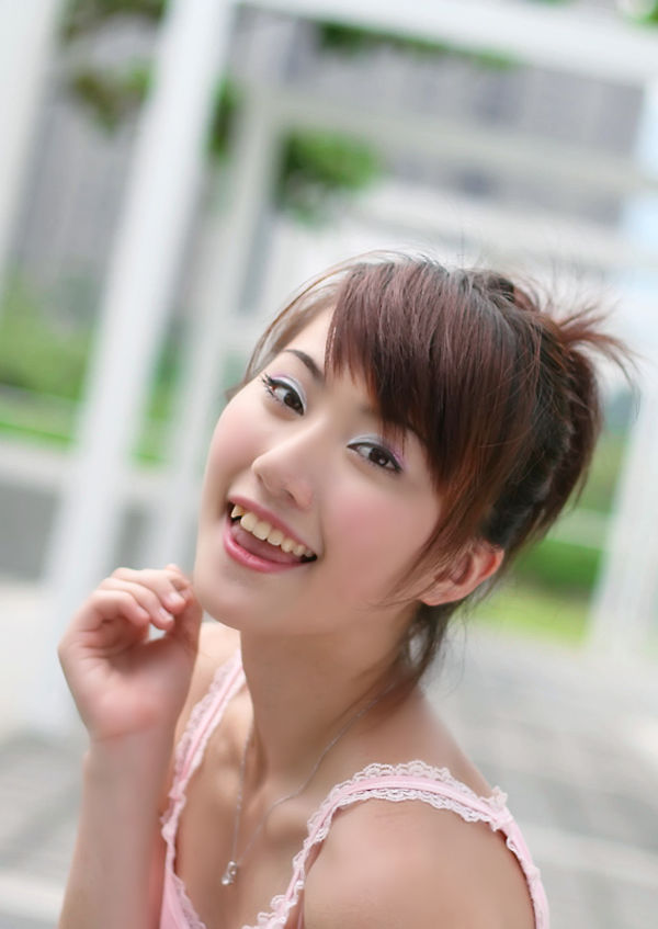 阳光下一个衣着粉色背心的清甜可爱小妹