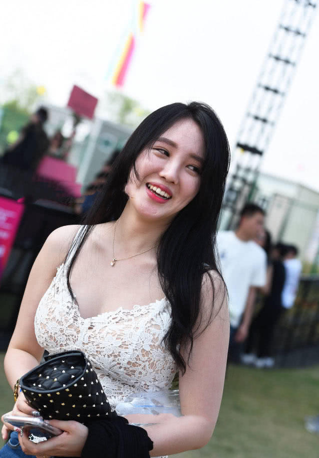 小姐姐在人群中很显眼，上边一件白色的蕾丝吊带，有点镂空的设计