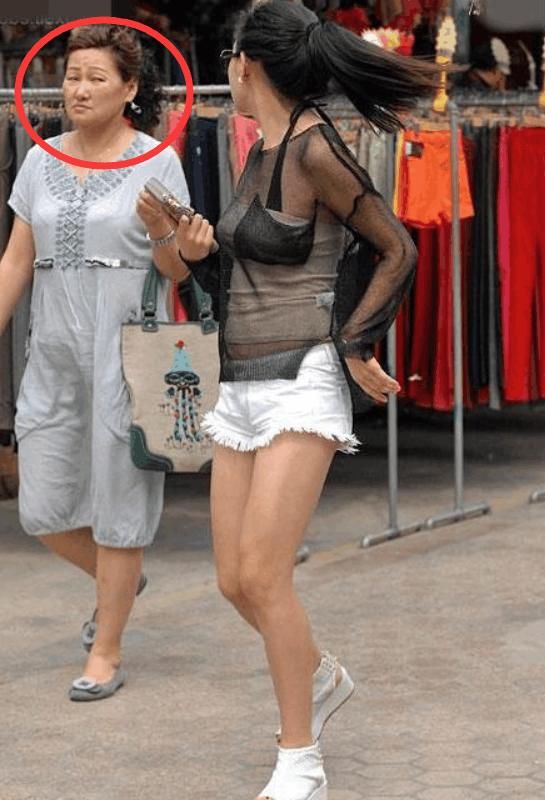 穿着透明装的少妇，大秀傲人上围，而旁边大妈传递来嫌弃的眼神！