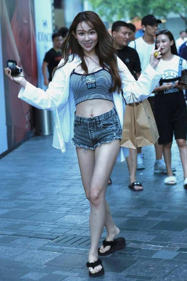 街拍：活泼可爱的小姐姐，穿毛边热裤还不断高抬美腿，显腿长？