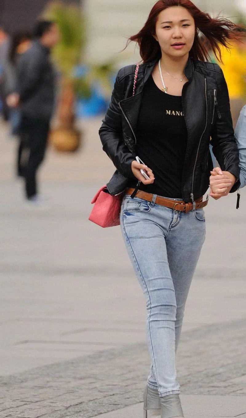 时尚小姐姐紧身牛仔裤搭配黑色皮衣，酷酷的中性穿搭让人眼前一亮