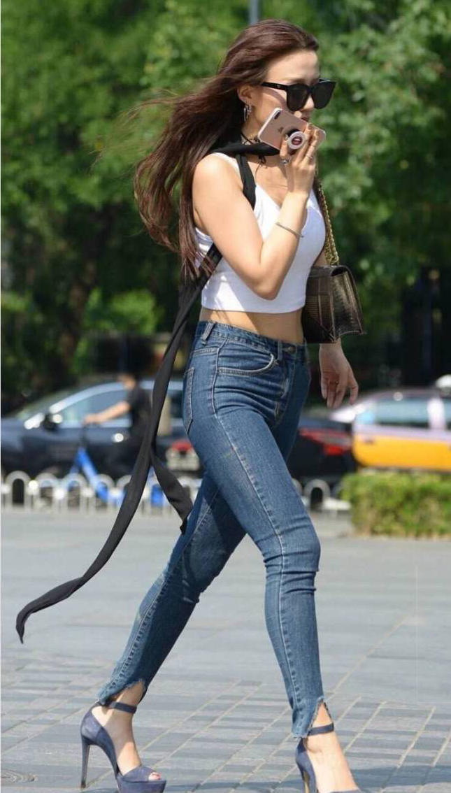 气质女神紧身牛仔裤裹出一双修长美腿，前凸后翘的身姿让MM非常有