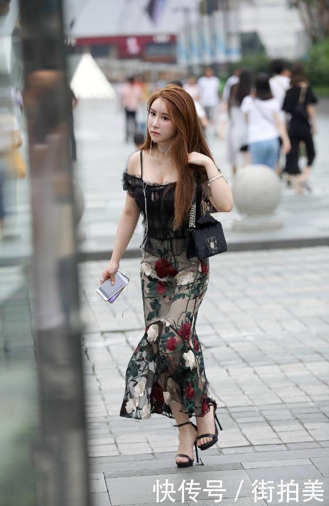 街拍：身穿薄纱吊带衣的小姐姐，胸前还开一个小口，美的很有别致