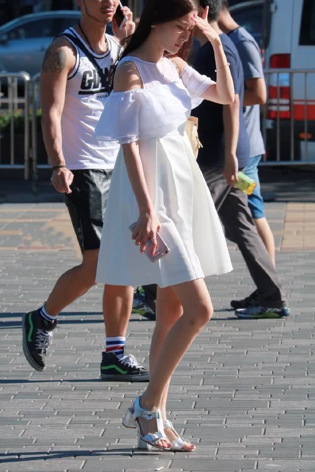 路人街拍，小姐姐身穿半边的抹肩，增添了几分性感的元素