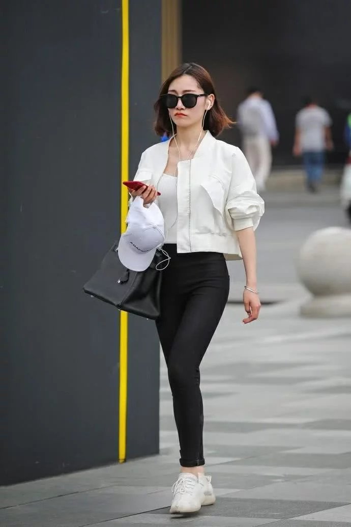 街拍：俏丽小姐姐白色修身背心搭配黑色紧身裤，时尚的穿搭秀出好
