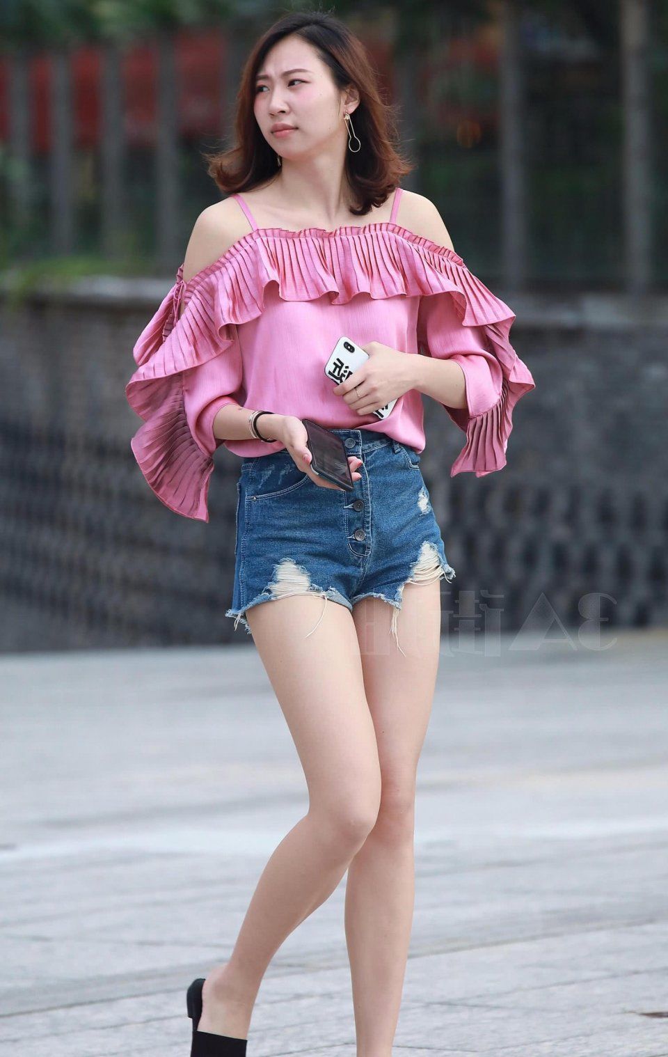 街拍美女:小姐姐牛仔短裤尽显修长美腿，玩起手机很优雅