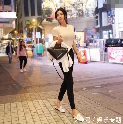 性感姐姐时尚街拍纯白色T恤搭配一款黑色的紧身热裤,凸显迷人好气