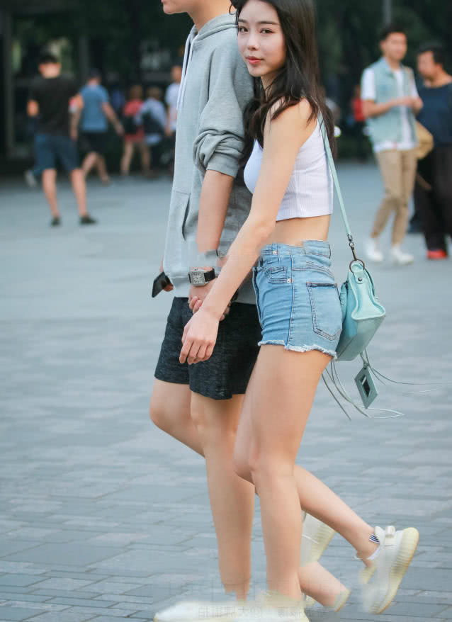 甜美小姐姐露脐装秀出白皙小蛮腰，超短裤裹出浑圆曲线，丸子头俏