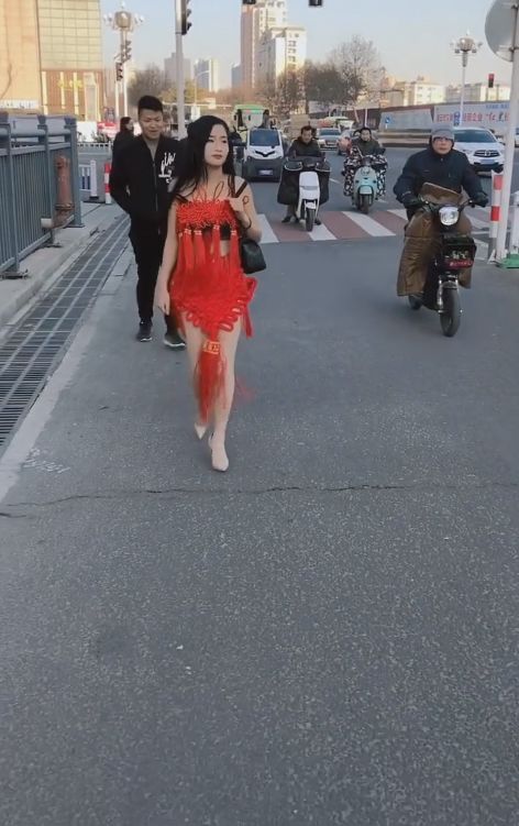 美女披着中国结衣服走在街头，路人表示大开眼界
