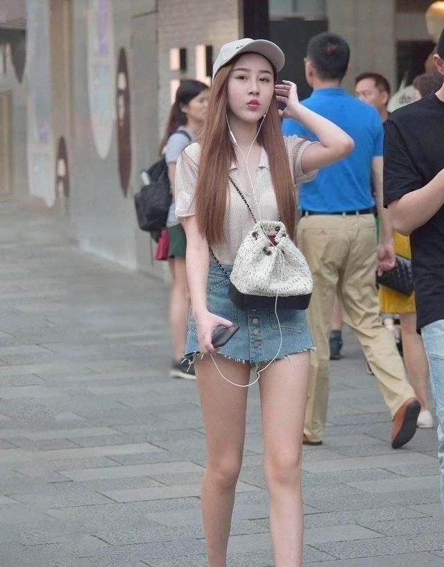 #气质#街拍小姐姐白色的长袖T恤搭配蓝色牛仔热裤,时髦靓丽