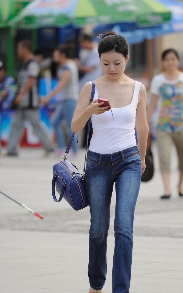 街拍:白色吊带低胸牛仔裤美女，腿真长