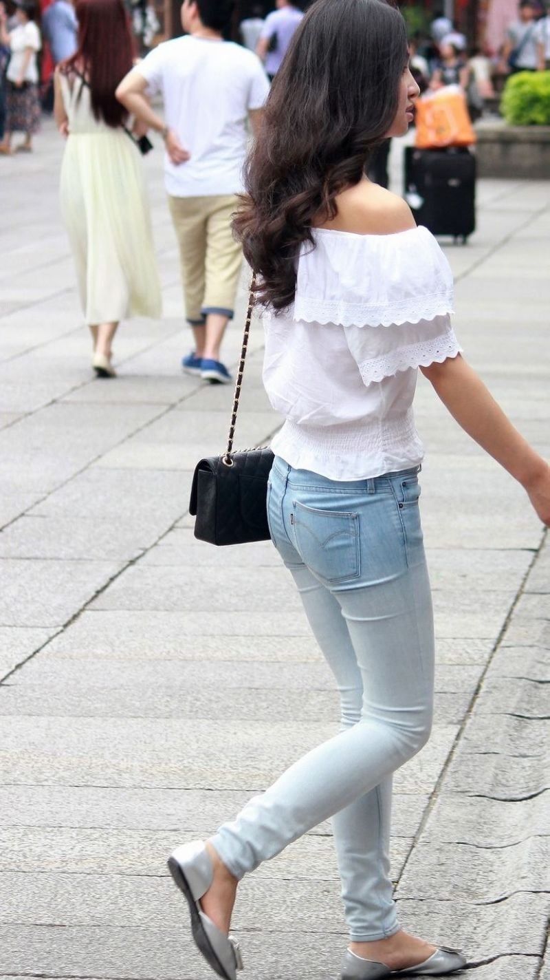 街拍:紧身牛仔裤露肩装美女，纤细的身材引人瞩目