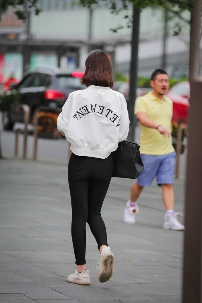 街拍：气质小姐姐紧身裤时尚美腿，一边走一边嘟嘴撩发萌态十足