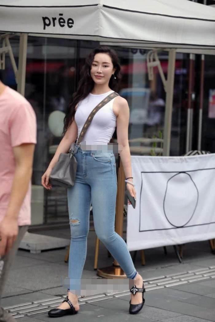 靓丽街拍: 丰盈紧身牛仔裤美女, 上身背心藏不住, 好羡慕啊!