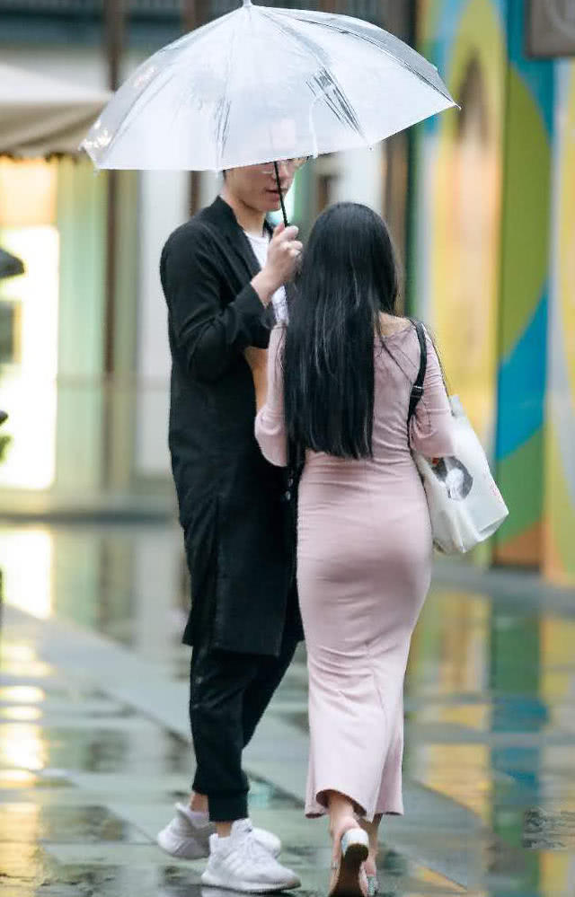 气质小姐姐和男友雨中漫步秀恩爱，包臀裙裹出了丰满的臀线