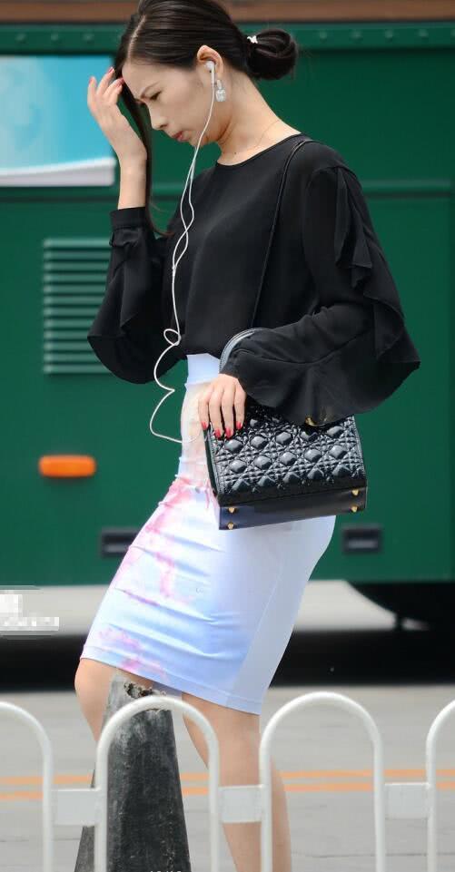 小姐姐上边穿着黑色的上衣，黑色显得稳重，浑身散发成熟女人香。