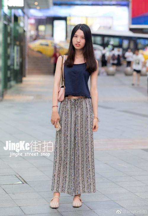路人街拍，小姐姐身穿一件细吊带的紧身裙，很有活力