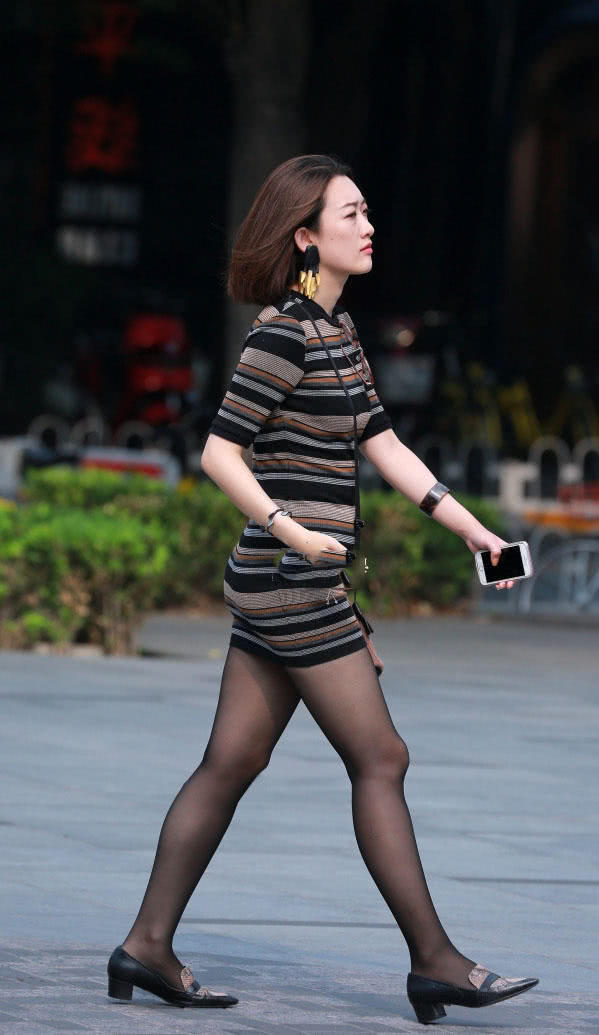 成熟少妇穿紧身裙配上黑丝袜秀出笔直的大长腿，曼妙的身姿很有魅