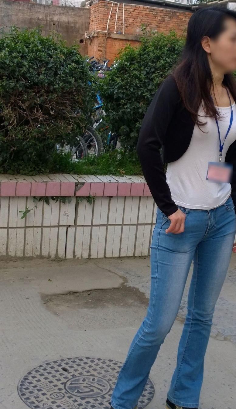 中学门口街拍:美女教师浅蓝色紧身裤搭配黑马甲，显迷人身段