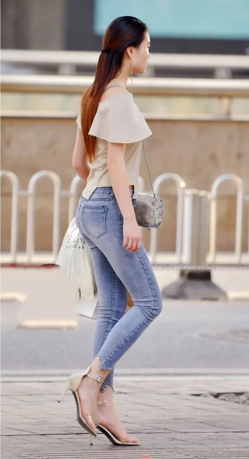 紧身牛仔裤御姐，气质高冷长相美艳，路边随意一坐，好身材一览无
