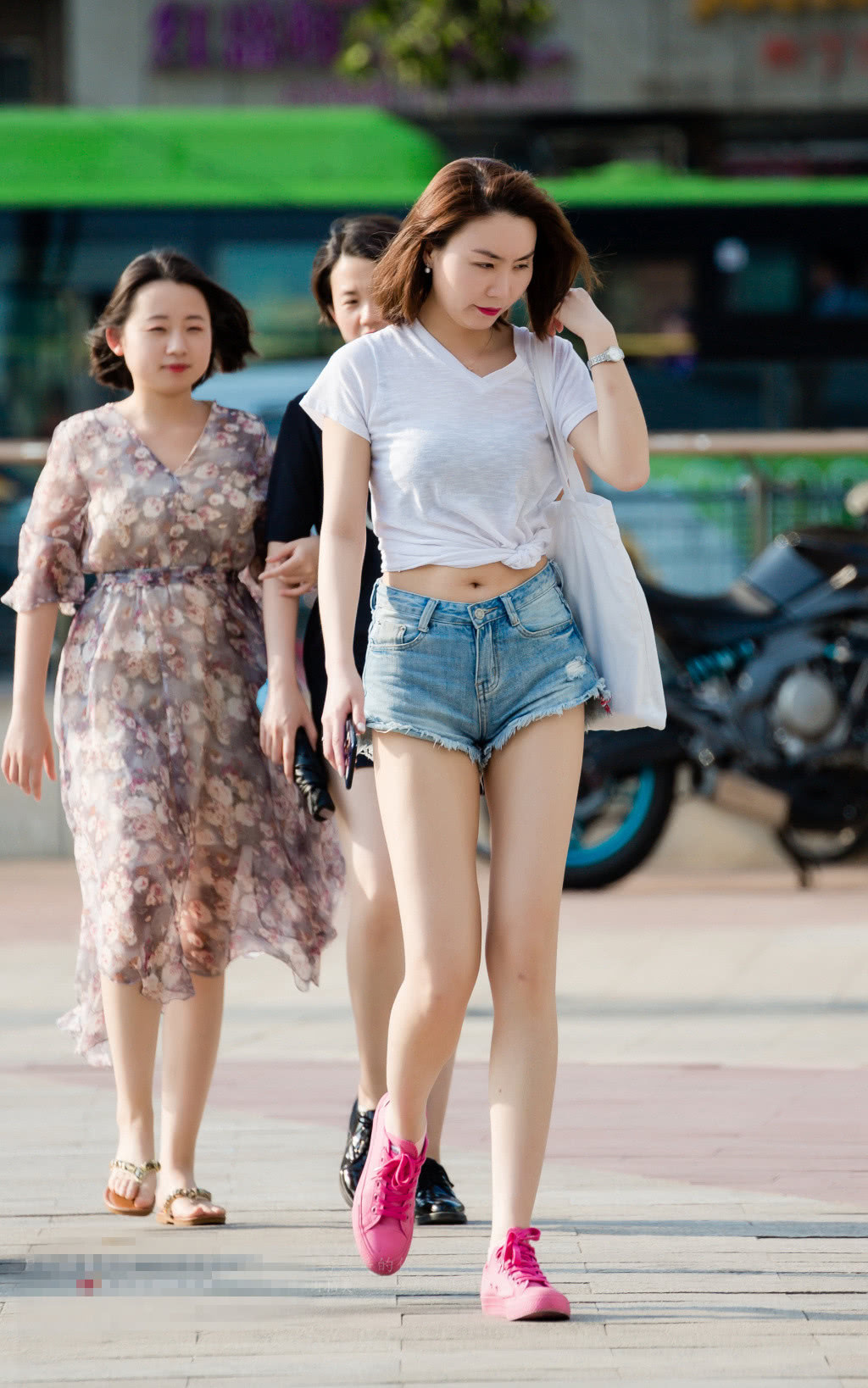 小姐姐白色的V领T,在腰部做了一个结，露脐的设计也是静静的性感