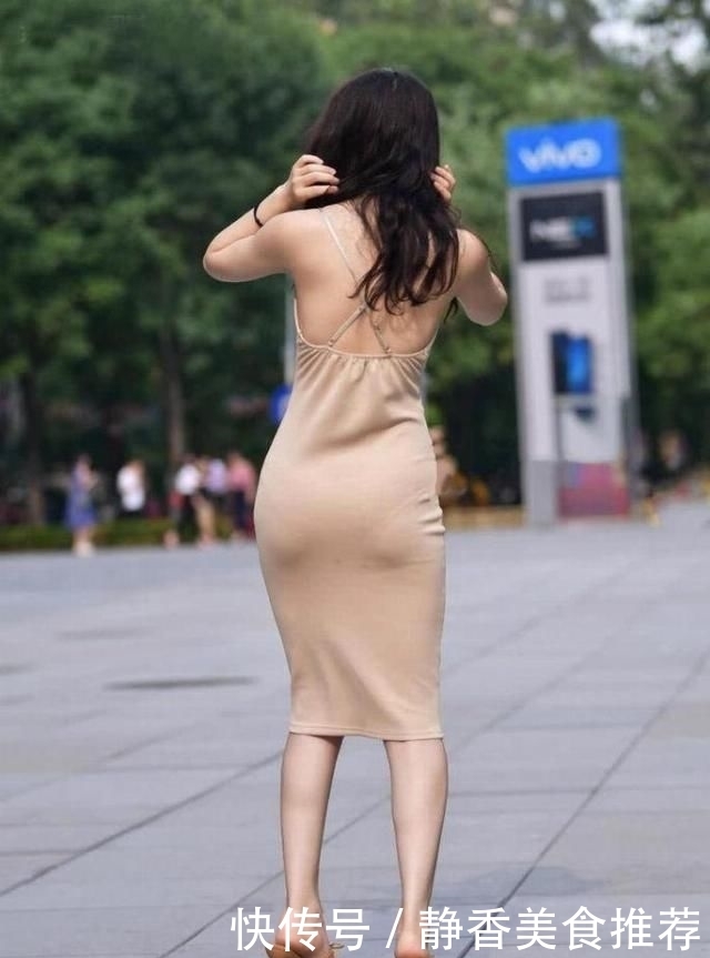  [身穿]街拍小姐姐身穿一条裸色吊带连衣裙非常的简单大方，魅力十足