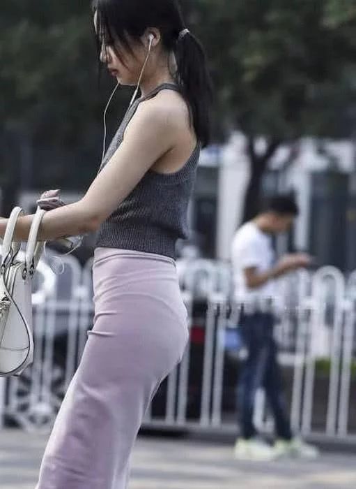 街头穿着时尚的美女,高腰包臀裙把身材比例拉伸的不错