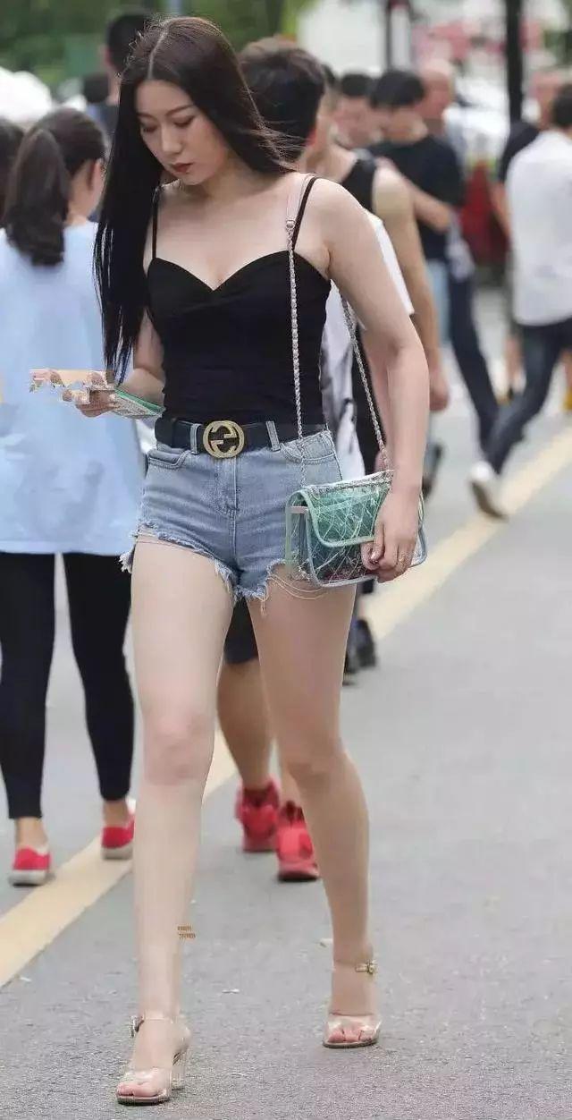 黑色细肩带背心搭配淡蓝牛仔短裤，身材姣好时髦呈现