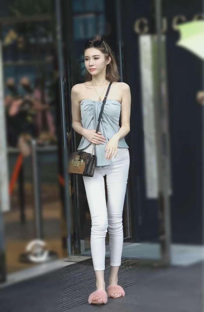 美女淡蓝色露肩的抹胸上衣真是好看，只是现身紧身牛仔裤有点尴尬