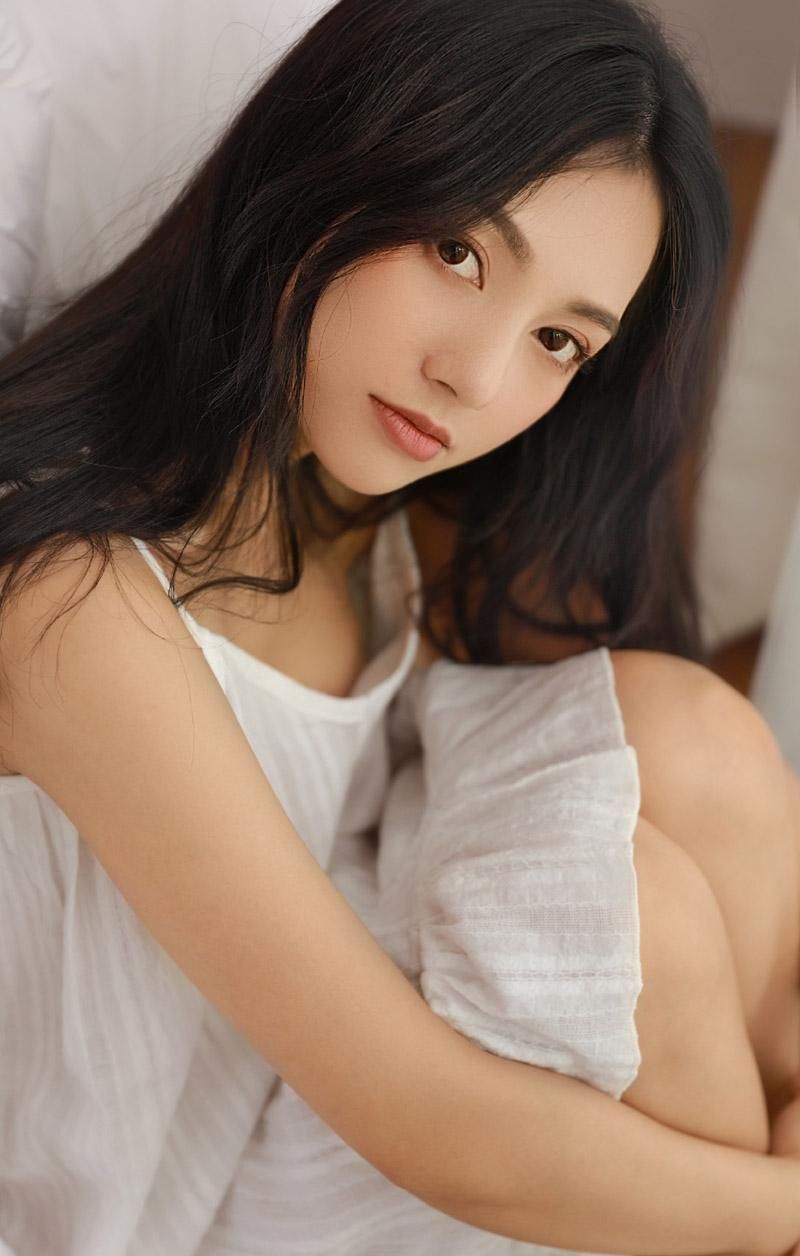 吊带裙美女性感慵懒床上写真图片