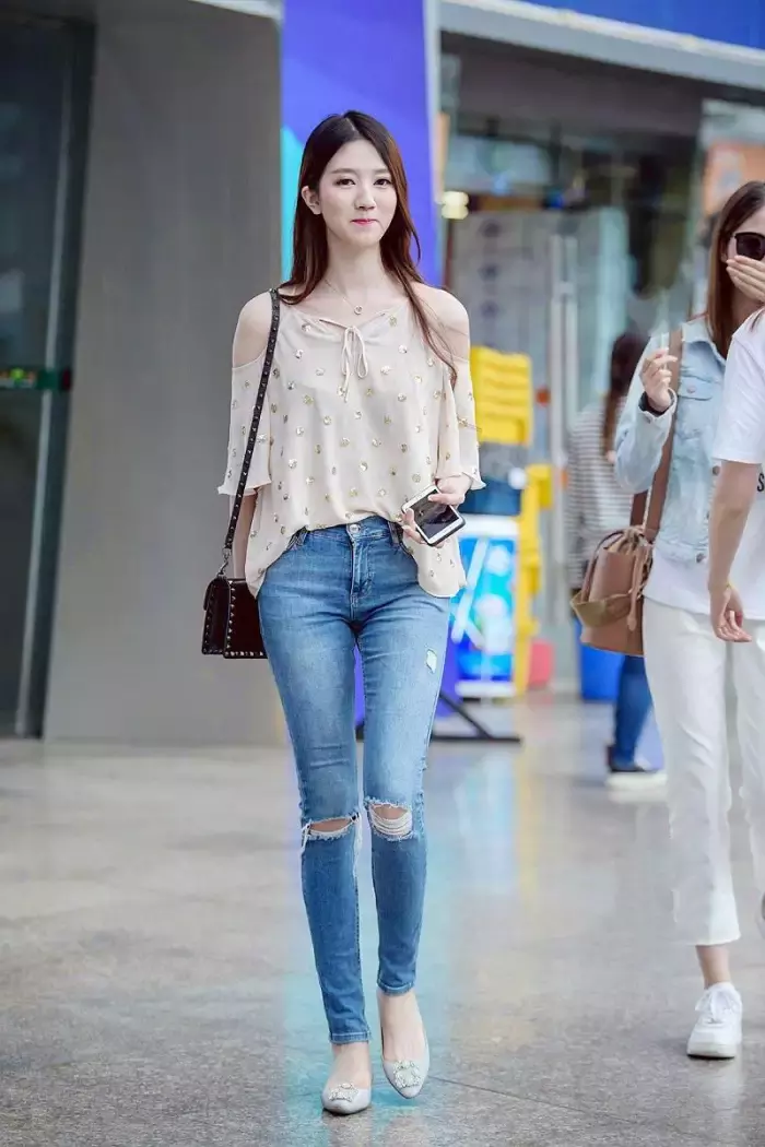 路人街拍，时尚的无袖上衣搭配干练的牛仔裤，打造出你的窈窕身姿