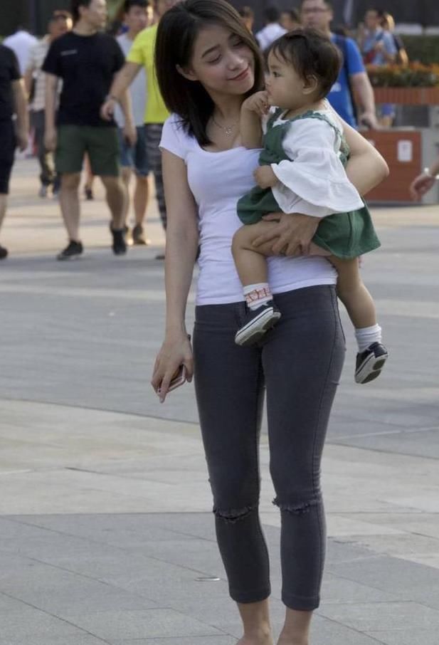 街拍美女：白色的t恤搭配黑色的紧身牛仔裤，辣妈身材很耐看