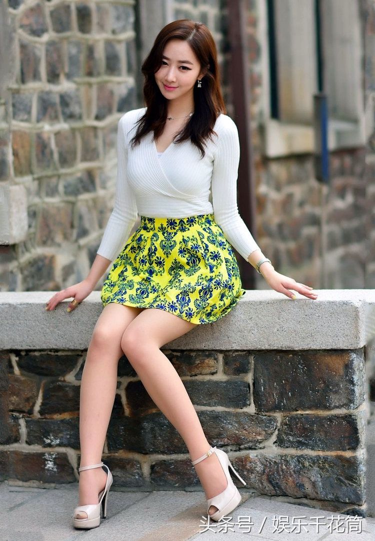 模特穿印花裙子少女感满满，坐路边栏杆心情很微妙