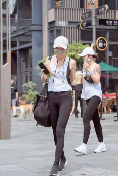 街拍：时尚小姐姐身材高挑，紧身裤大秀修长双腿街头撞衫犹如双胞